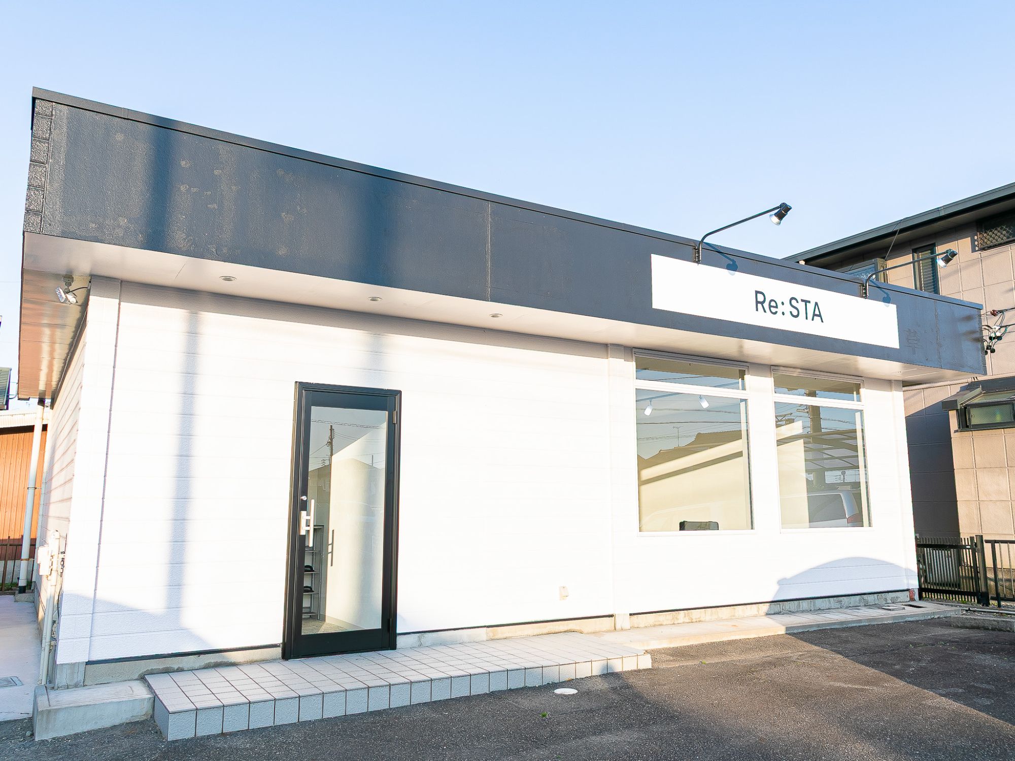 Re:STA 尾張旭店の外観。白い建物に Re:STA の看板
